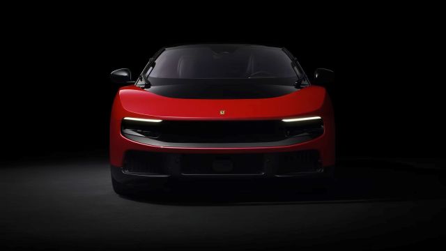A red sports car with distinctive headlights against a black background.