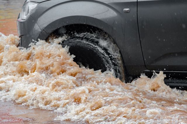 A car driving through a flooded street.