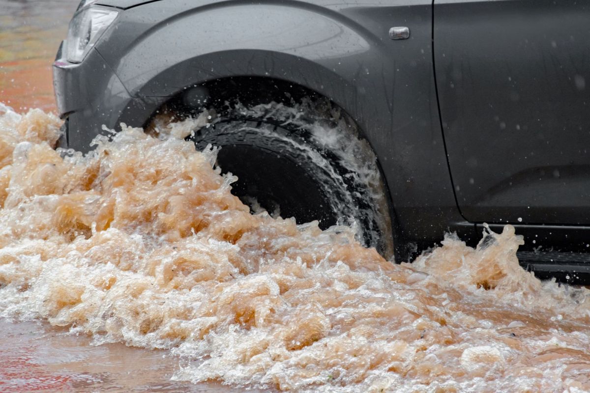 A car driving through a flooded street.