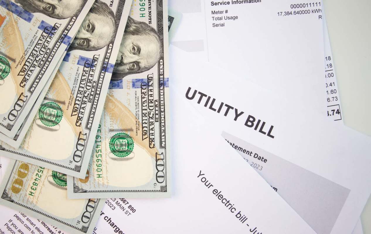 Cash bills and a utility bill are scattered on a flat surface.