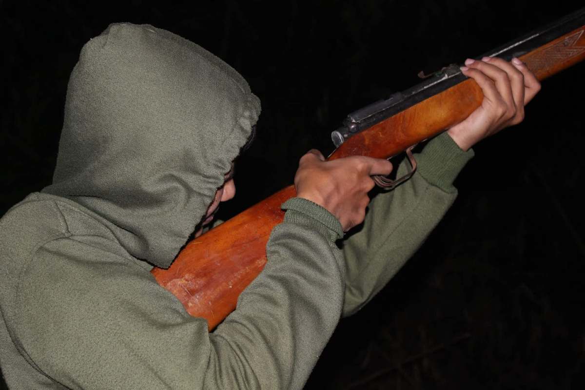 A person aiming a rifle.