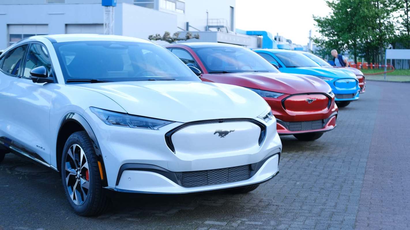 A row of colorful electric cars parked on a paved surface.