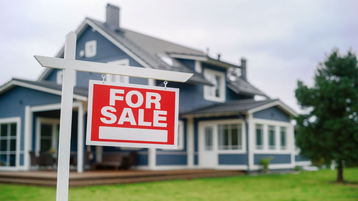 A "For Sale" sign in front of a home.