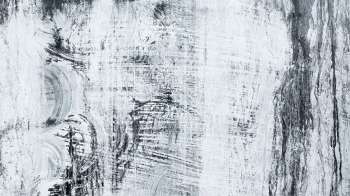 An abstract texture of black and white brush strokes on a surface.