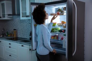 A woman looking in the fridge.