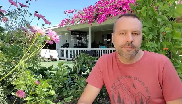 A man sitting in a garden.