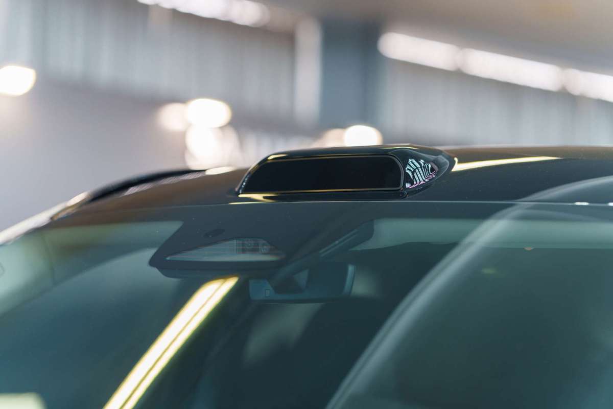 A car roof with a black antenna and additional sensors visible.