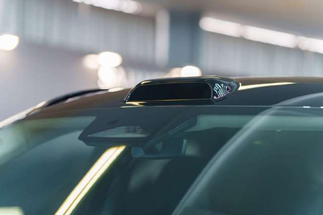 A car roof with a black antenna and additional sensors visible.