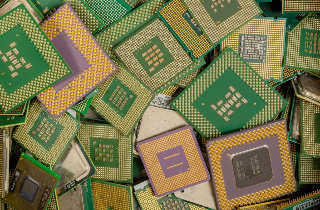 A pile of various computer processors with green circuit boards and gold pins.
