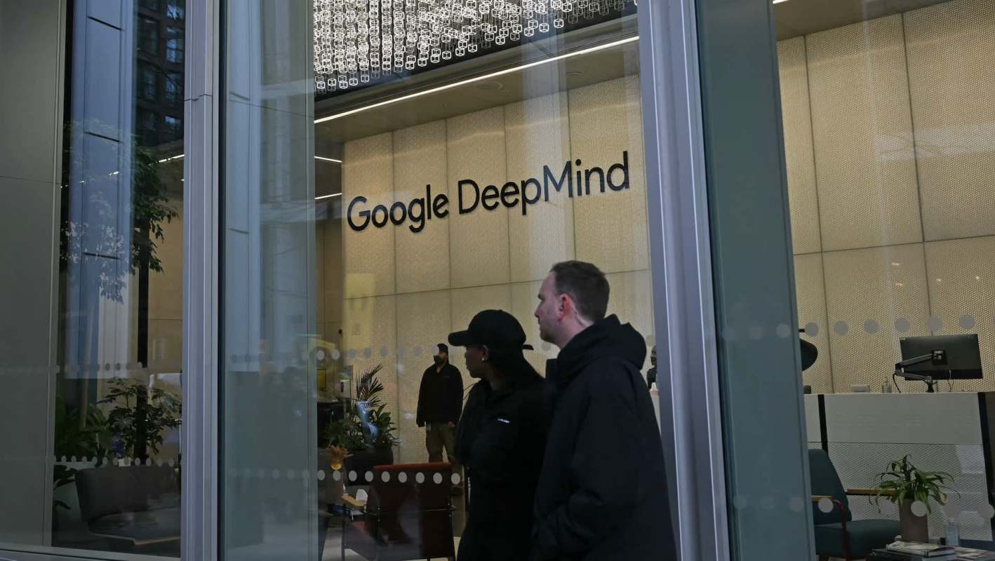 A storefront displaying the "Google DeepMind" logo with people outside.