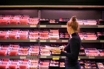 A person looking at ground beef.