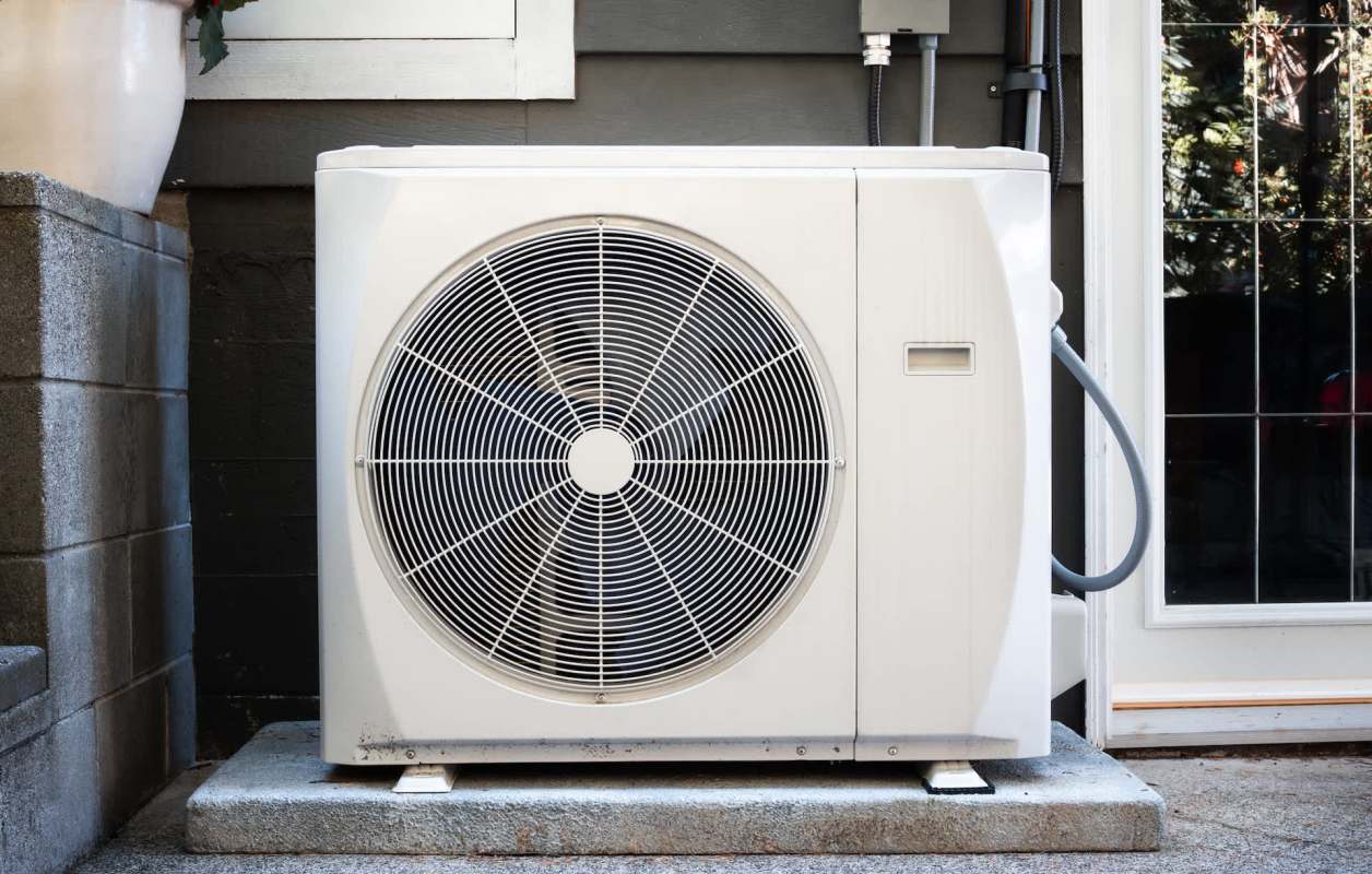 An outdoor heat pump unit installed beside a home.
