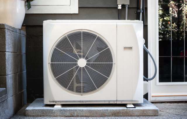 An outdoor heat pump unit installed beside a home.