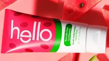 A tube of watermelon-flavored toothpaste with a bright pink and white label surrounded by watermelon slices.