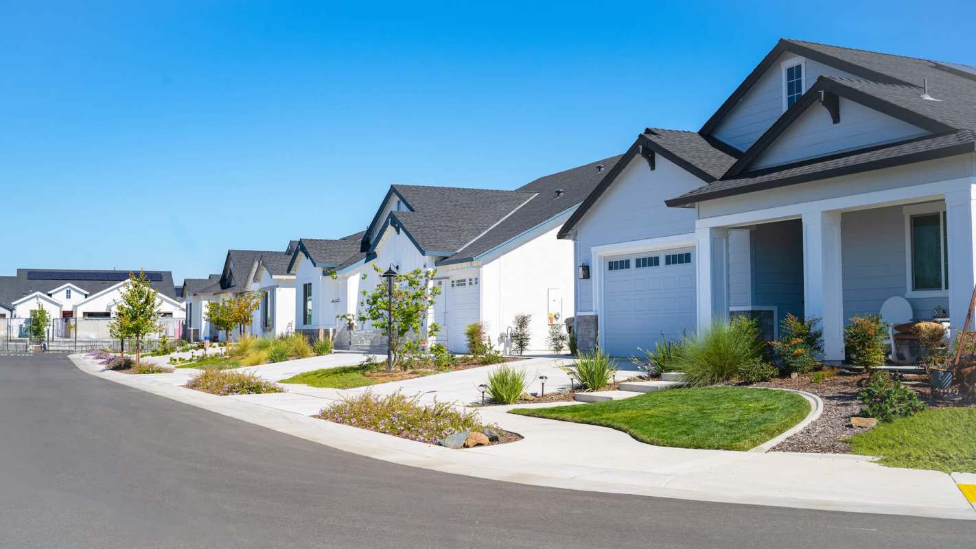 A row of houses with well-maintained gardens and walkways on a clear day.