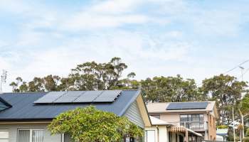 Two residential buildings with rooftop solar panels.