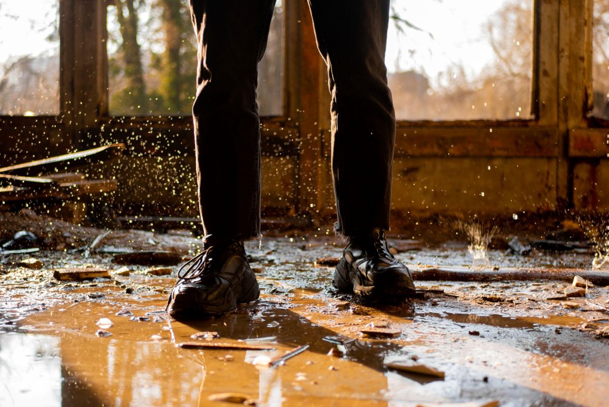 A person standing in a home that was flooded.