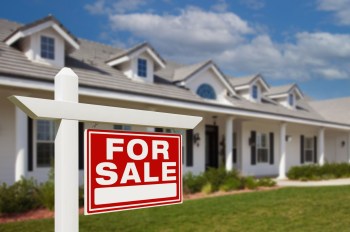 A "for sale" sign in front of a home.