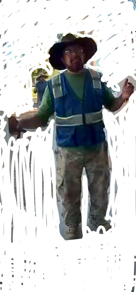 Another man in a work vest.