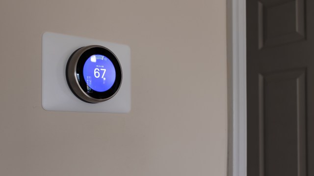 A digital thermostat on a wall.