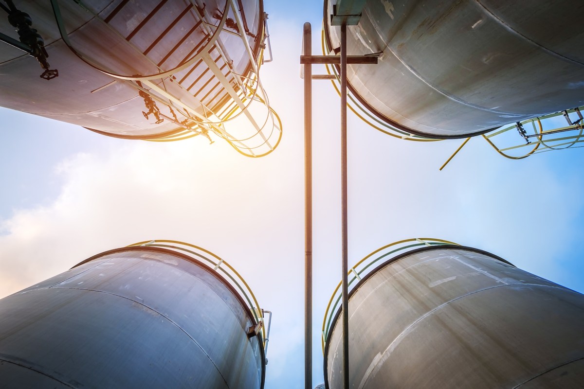 Four water storage tanks against the sky