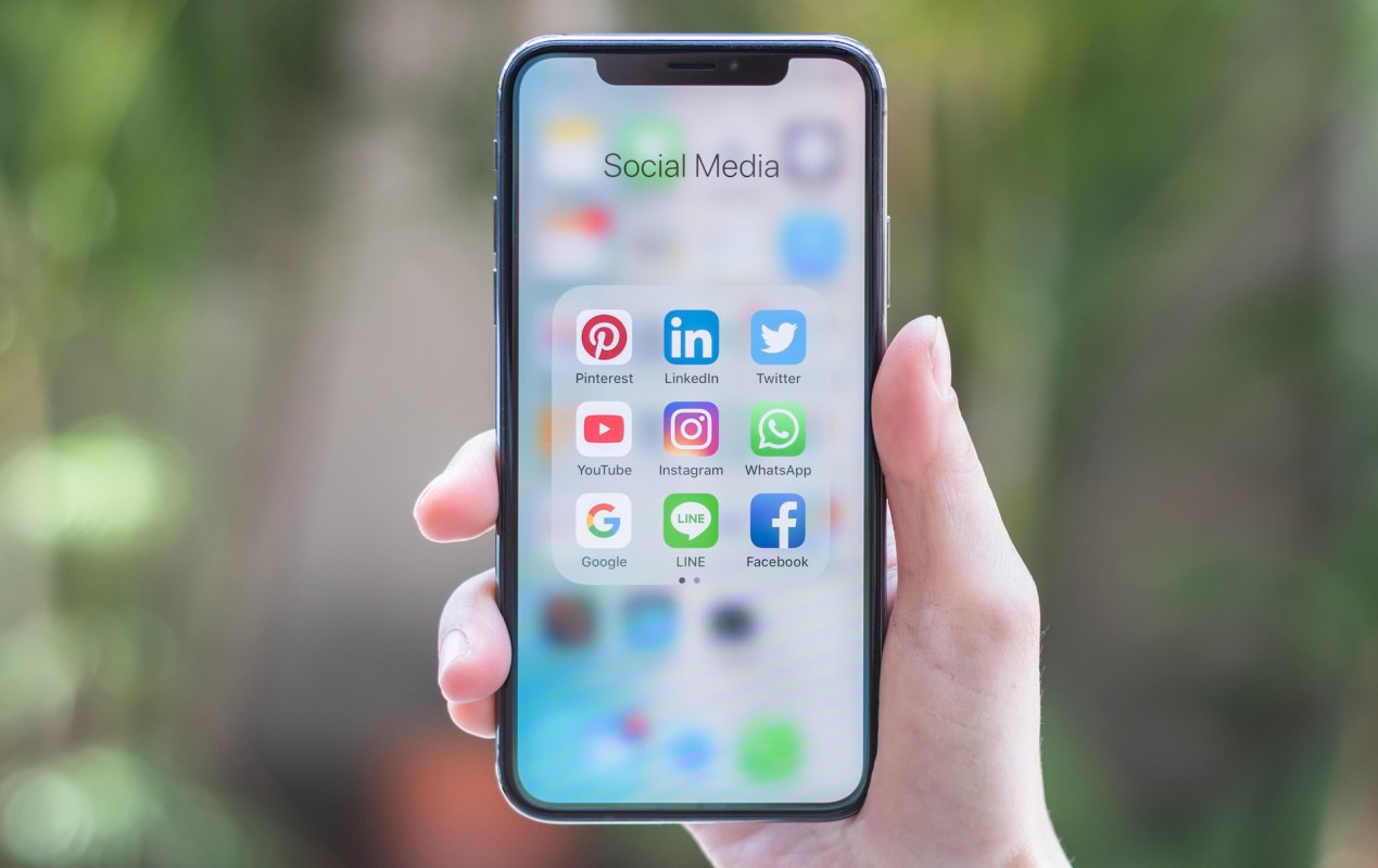 A person holds up an iPhone X.