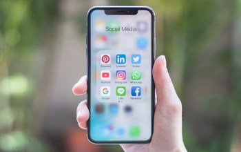 A person holds up an iPhone X.