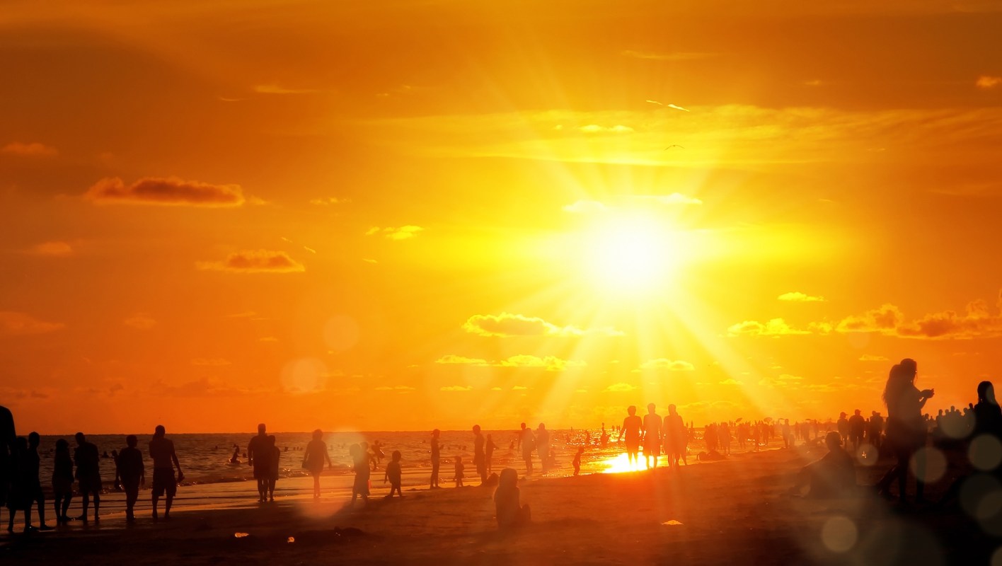 People on a beach at sunset.