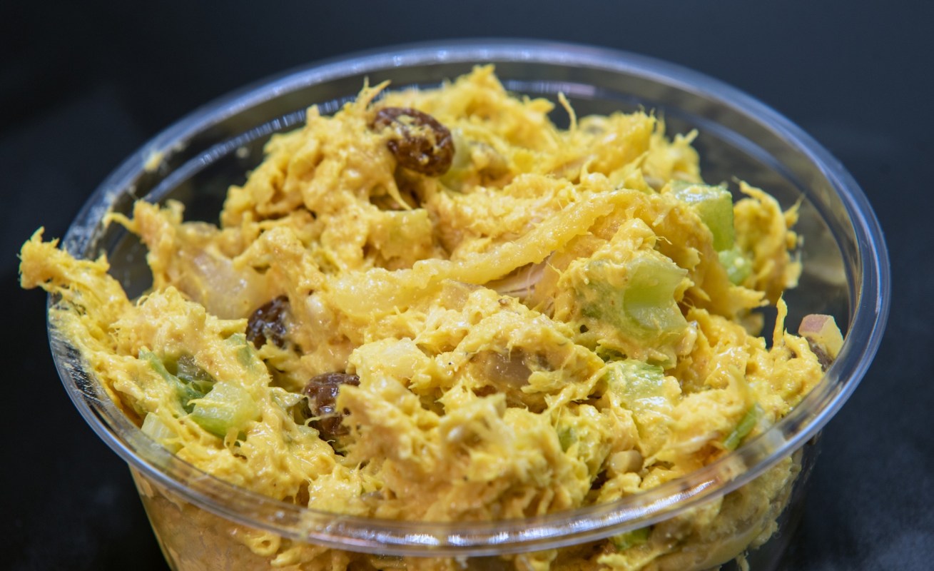 A container of yellow curry chicken salad.