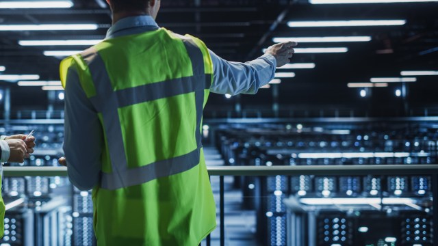 A data center worker in a reflective vest.