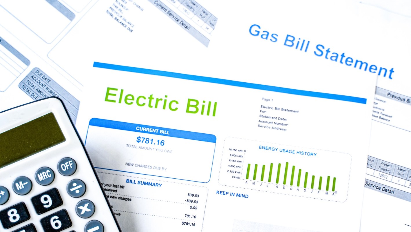 An electric bill statement with a calculator and additional utility documents.