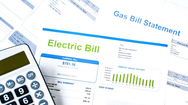 An electric bill statement with a calculator and additional utility documents.