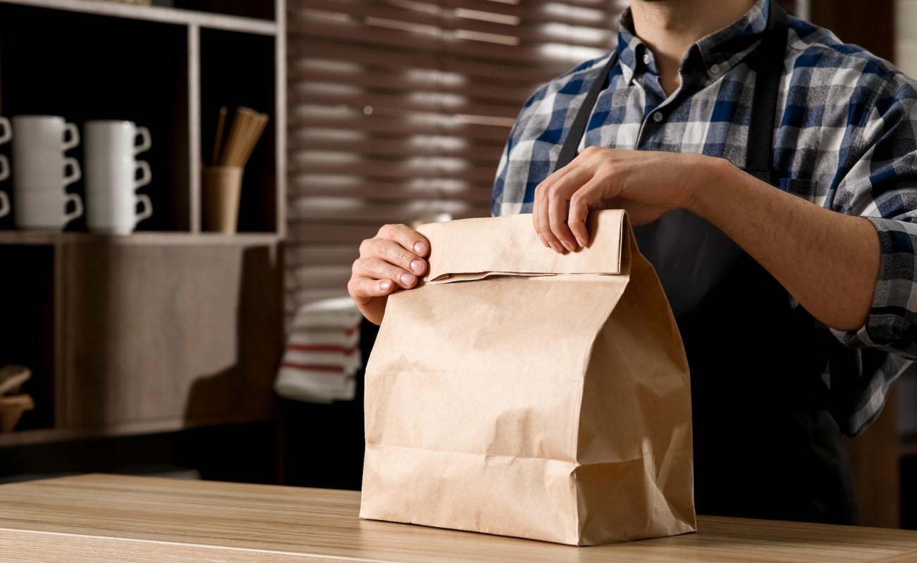 A person with a brown paper bag.