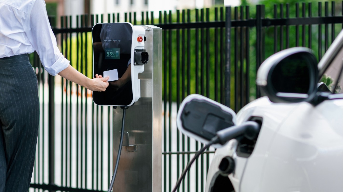 A person charging an EV.