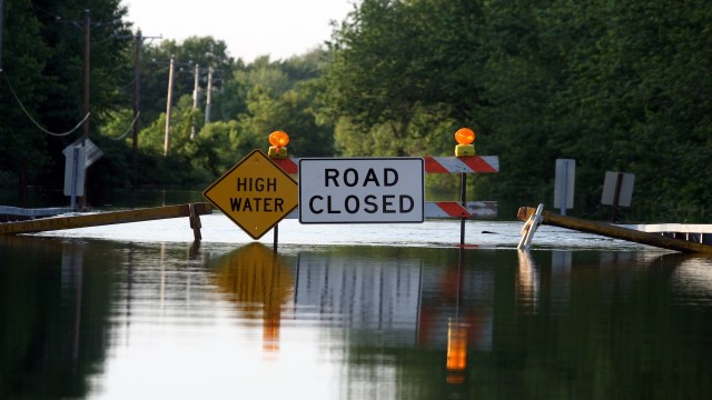 A flooded road with a "Road Closed" sign and "High Water" warning.