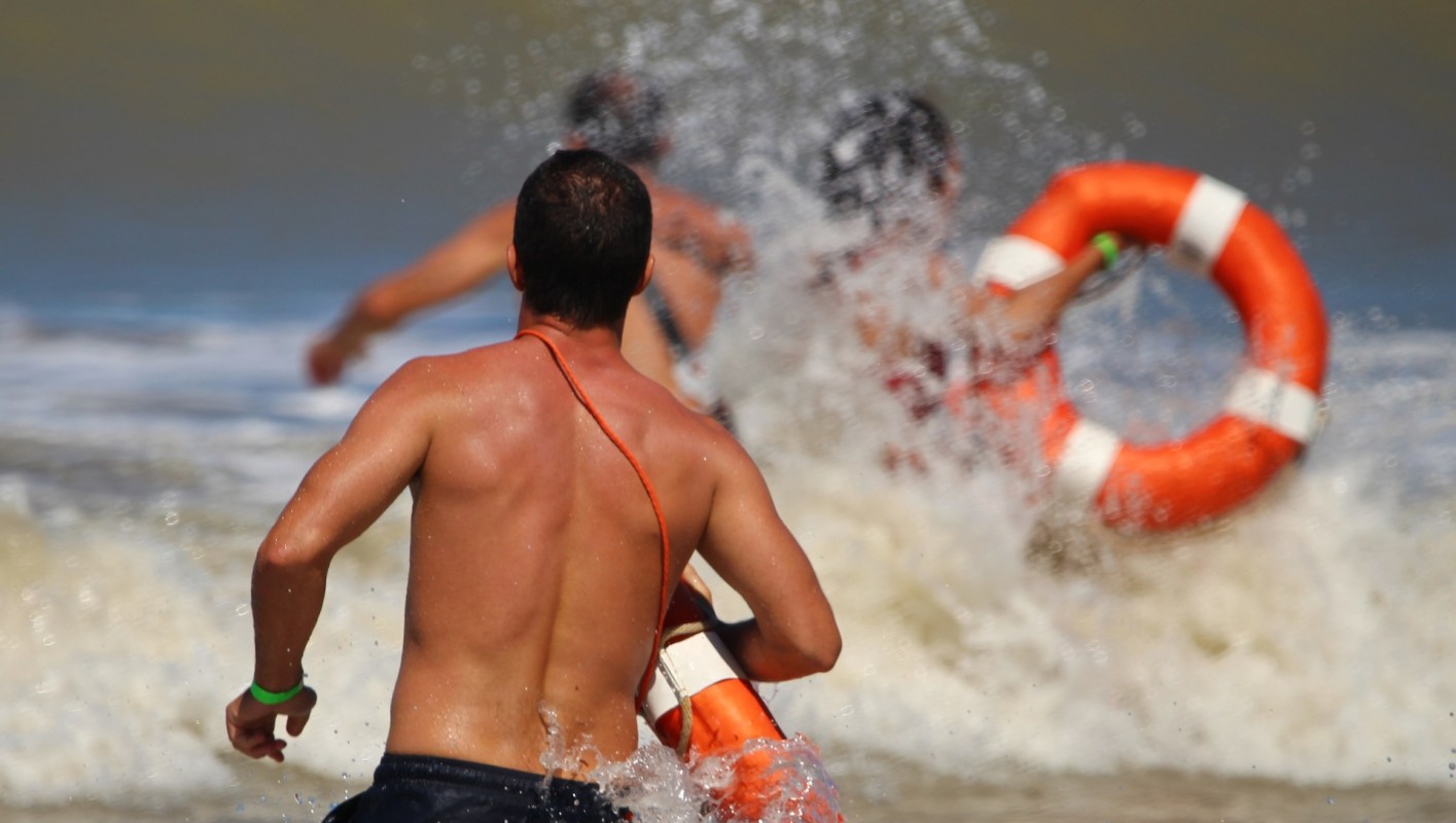 A lifeguard runs into the ocean.