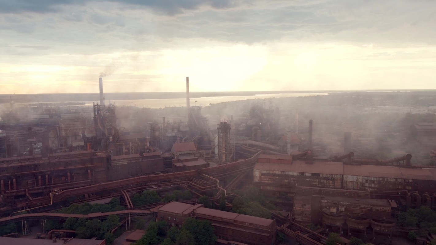 An industrial landscape with smokestacks and coal factories under a cloudy sky.