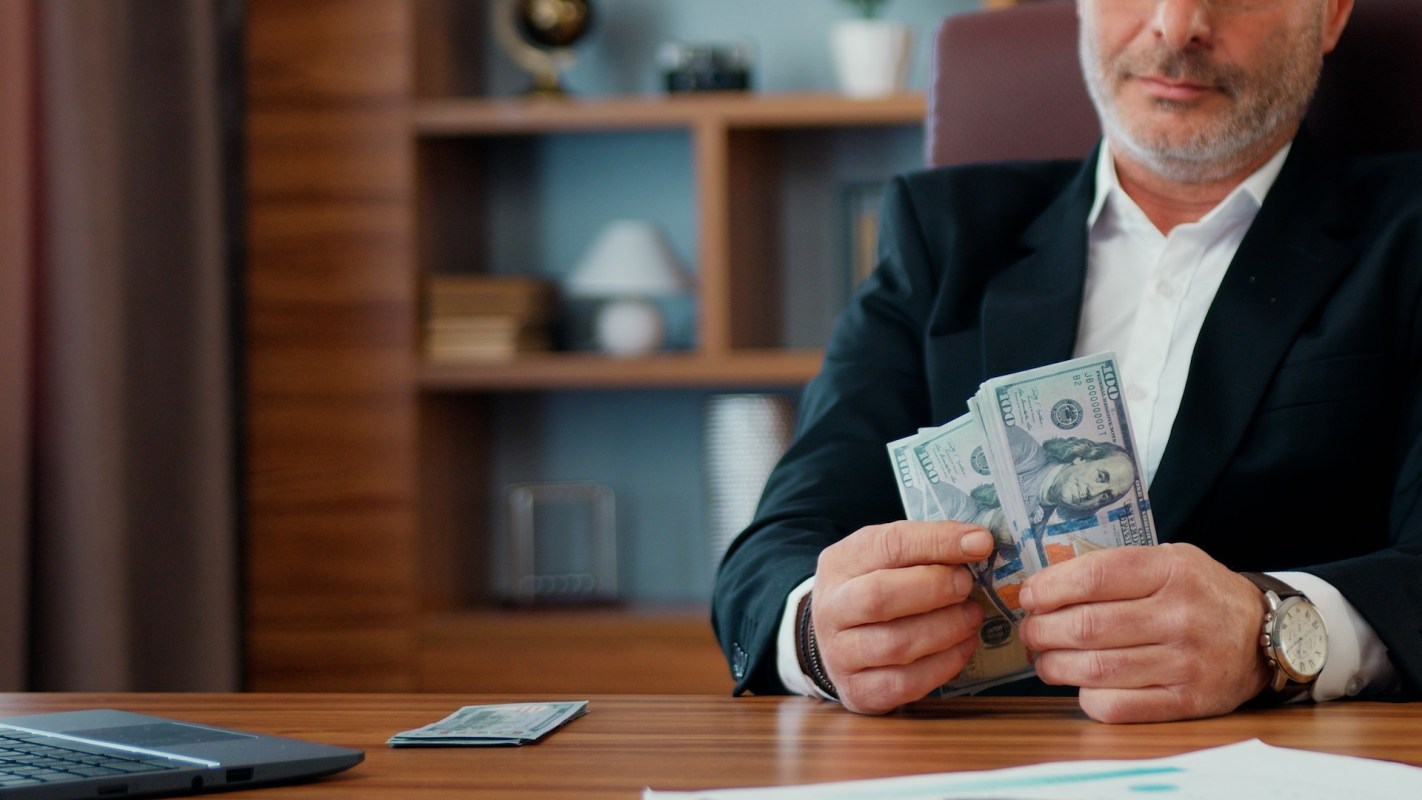 A businessperson holding a stack of cash.