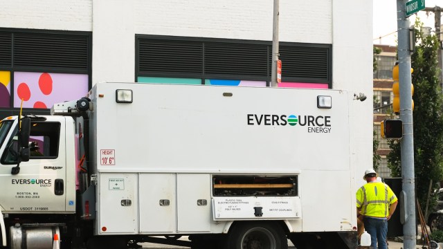 A utility truck from Eversource Energy parked next to a building with colorful graphics.