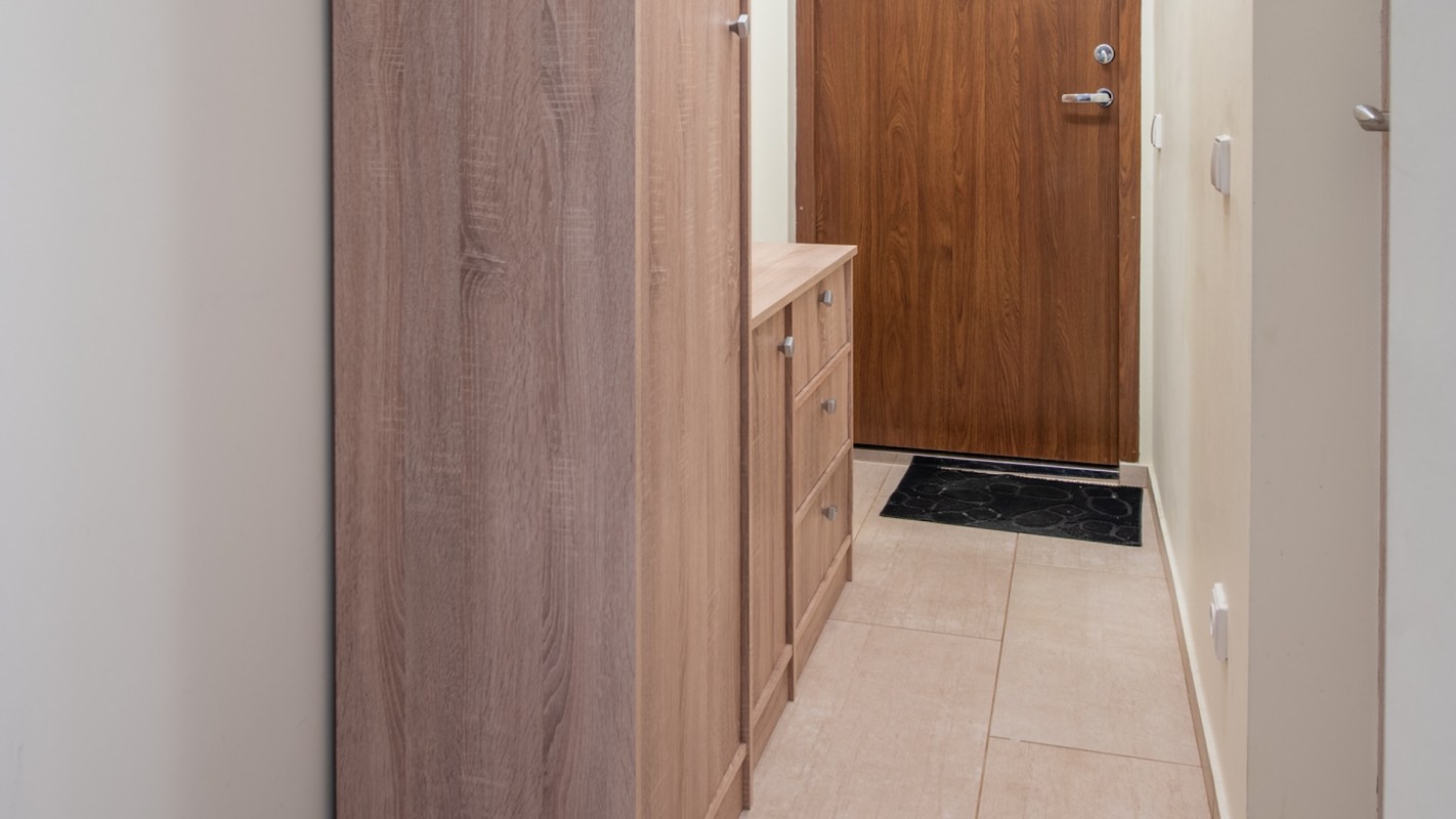 A hallway with a wardrobe and dresser.