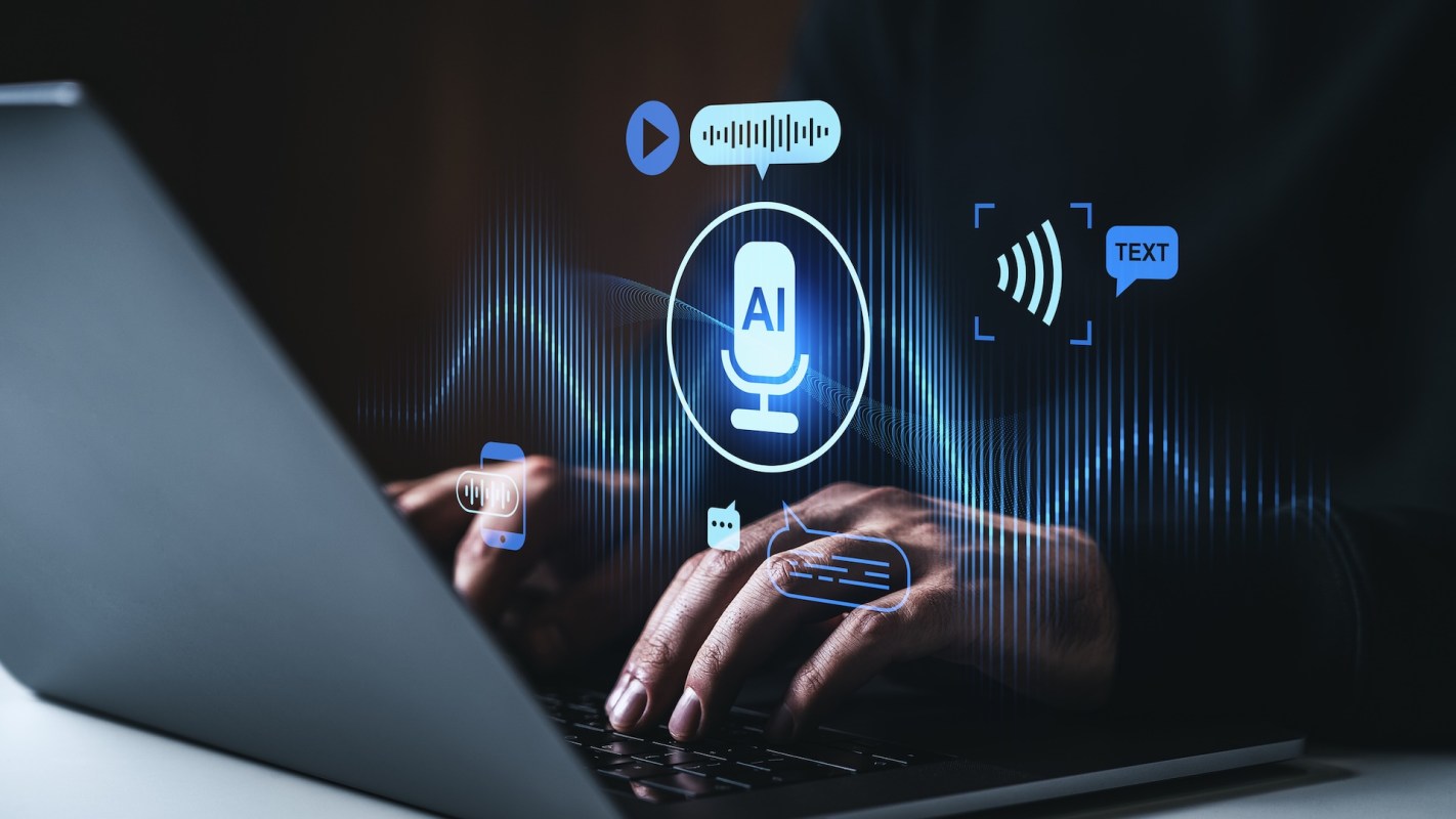 A person types on a laptop with digital sound and AI icons displayed.