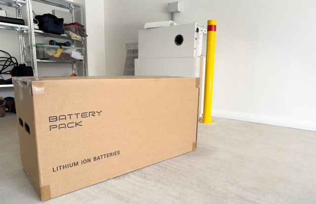 A cardboard box labeled "Battery Pack" in a storage area with shelves in the background.