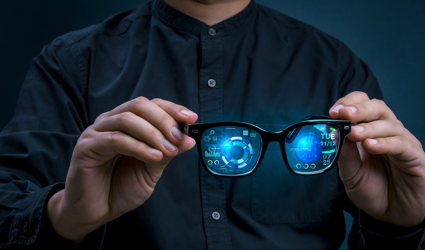 A person holding augmented reality glasses.