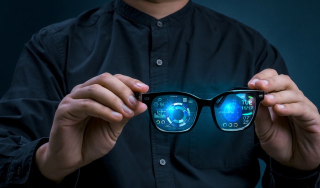 A person holding augmented reality glasses.
