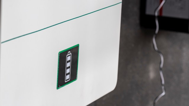 A battery status indicator displayed on a white home battery with a cable connected.