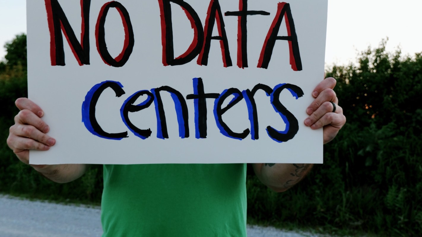 A person holding an anti-data center sign.