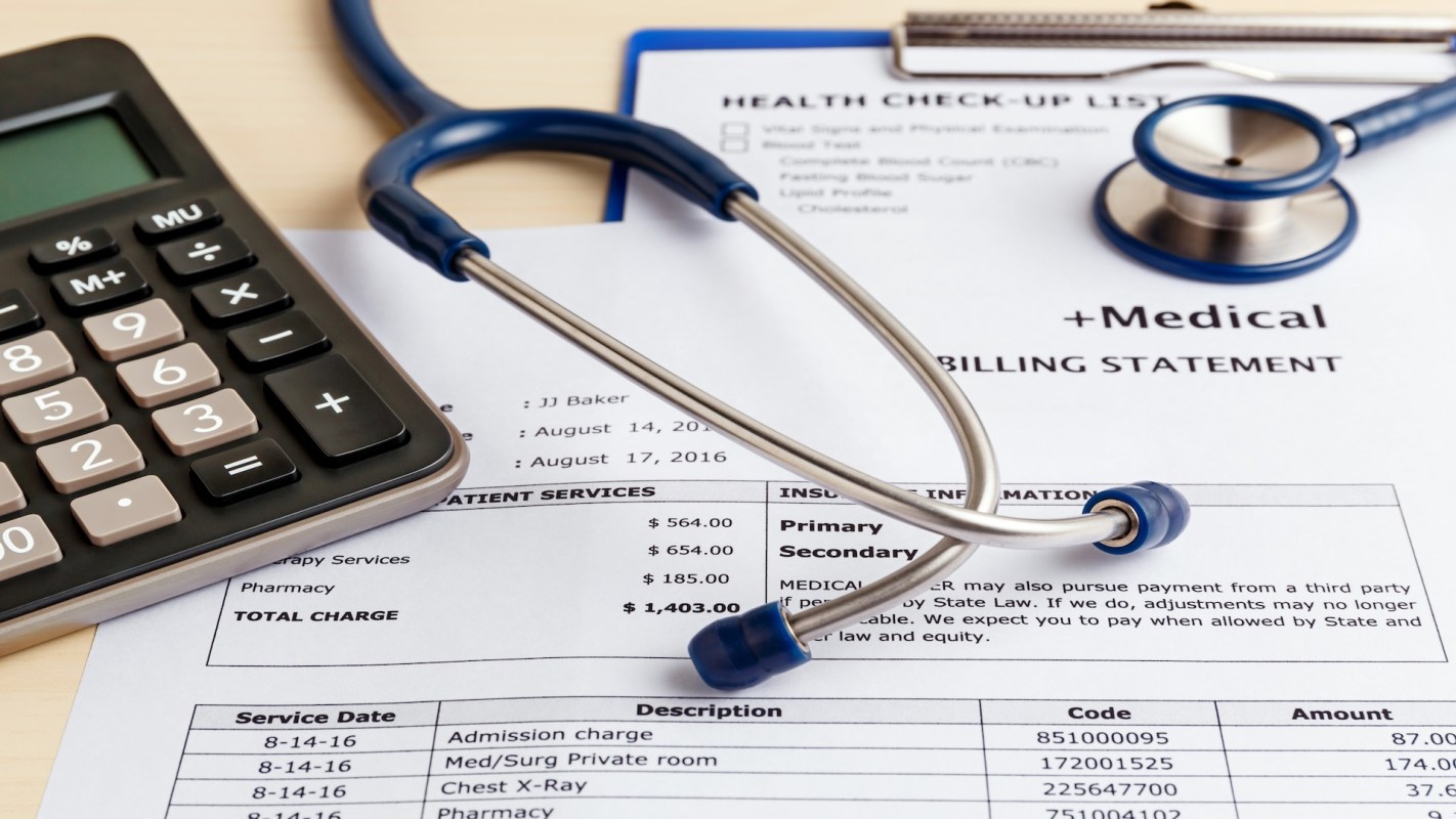 A stethoscope rests on a sheet of financial data next to a calculator.