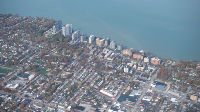 An aerial view of a city with residential buildings and a lake in the background.