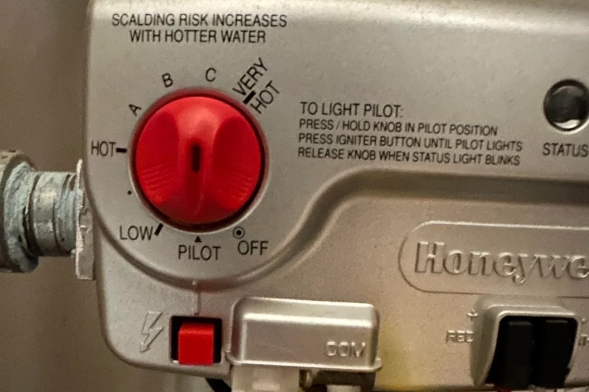 A gas control knob labeled with temperature settings and instructions for lighting the pilot on a water heater.