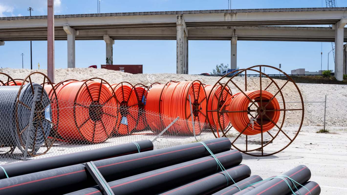 Spools of cable and pipes at a construction site.